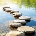 Peaceful stepping stones path across calm water, symbolizing the journey of active stewardship and building a godly legacy