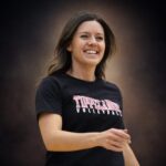 Ashley Flynn smiling while coaching volleyball, reflecting the light and joy she brought to her community