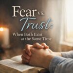 A mother’s hands resting on an open Bible during a quiet moment of prayer, reflecting fear and trust existing at the same time.